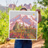 A vibrant, multicolored giclee print featuring a Mount Rainier with trees and a sun in the background.