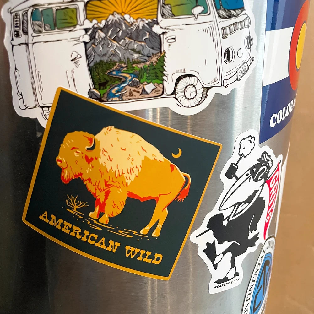 American Wild Bison sticker on metal pole surrounded by other stickers. 